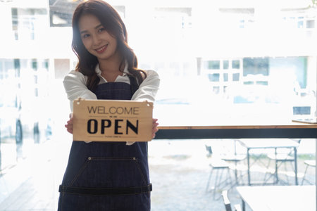 Portrait of a woman, a coffee shop business owner smiling beautifully and opening a coffee shop that is her own business, Small business concept.の写真素材