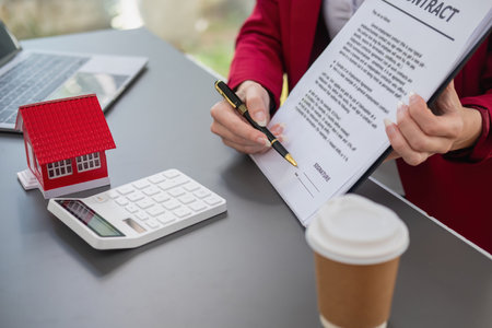 Accountant, businessman, real estate agent, Businessman handing model house to customers along with house interest calculation documents for customers to sign.の写真素材