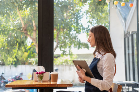 Portrait of a woman, a coffee shop business owner smiling beautifully and opening a coffee shop that is her own business, Small business concept.の写真素材