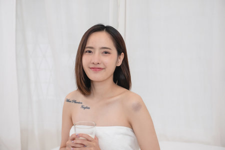 Portrait of young cheerful Asian woman drinking healthy milk on the morning of the holiday Good rest and healthy lifestyle concept.の写真素材