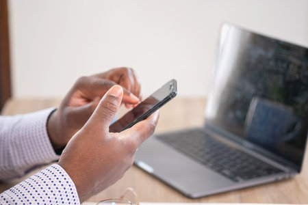 African black businessmen sit on mobile phones communicating with clients and making financial...