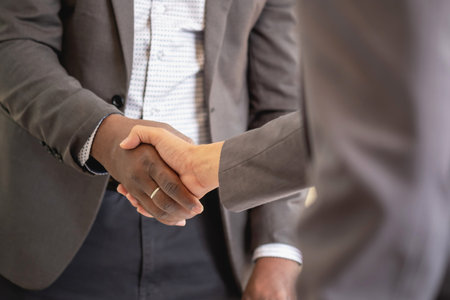 Satisfied black client shaking hands, thanking the manager for good financial deal African American businessmen shaking hands after successful business negotiations. Hiring. Buying services.の写真素材