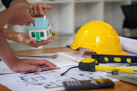 Asian engineers brainstorm and measure to document cost estimates and write floor plans for architectural and engineering designs for houses and buildings.の写真素材