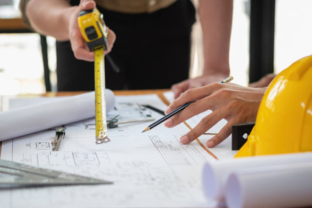 Asian engineers brainstorm and measure to document cost estimates and write floor plans for architectural and engineering designs for houses and buildings.の写真素材