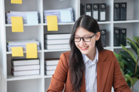 businesswoman working in the office Using calculator to calculate financial reports. Sales data with laptop computer and business documents on office table. Close up. Business finance and investment.の写真素材