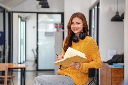 Happy latin girl college student watching distance online learning class, remote university webinar or having talk on laptop video call and use notebook to virtual meeting seminar at home or campusの写真素材
