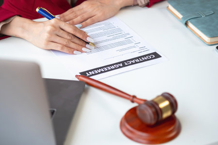 Asian female lawyer or legal advisor signing a contract The contract documents that work on your desk in the law office are there to guide you.の写真素材
