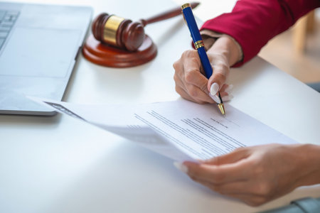 Asian female lawyer or legal advisor signing a contract The contract documents that work on your desk in the law office are there to guide you.の写真素材