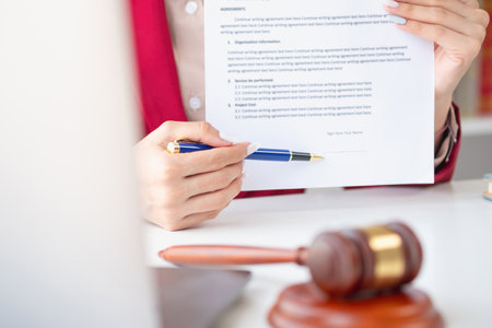 Asian female lawyer or legal advisor signing a contract The contract documents that work on your desk in the law office are there to guide you.の写真素材
