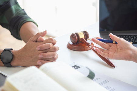 Asian female lawyer or legal advisor signing a contract The contract with the client on the desk in the law firm will guide the client as a legal counsel.の写真素材