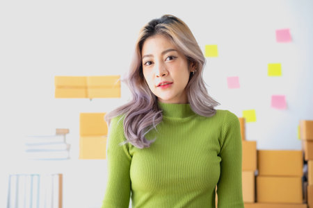 Portrait of an Asian woman with a beautiful face tied in a brown ponytail and fresh clean skin. Cute model, with natural make-up and parted, sparkling eyes.の写真素材