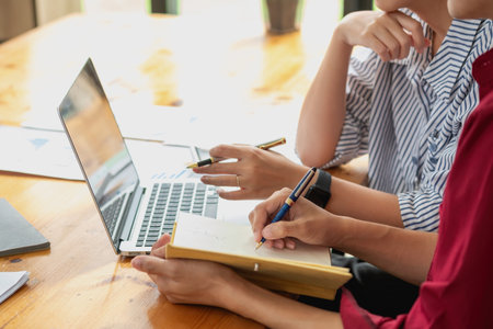 Marketing, Financial, Accounting, Planning, Team of business women analyze company results and profits with graph statistics. Use a laptop computer and a calculator to calculate the company balance.の写真素材