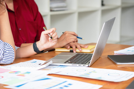 Marketing, Financial, Accounting, Planning, Team of business women analyze company results and profits with graph statistics. Use a laptop computer and a calculator to calculate the company balance.の写真素材