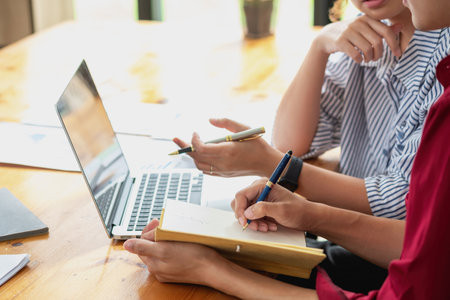 Marketing, Financial, Accounting, Planning, Team of business women analyze company results and profits with graph statistics. Use a laptop computer and a calculator to calculate the company balance.の写真素材