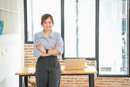 Portrait of a woman business owner showing a happy smiling face as he has successfully invested in her business using tablets and financial budget documents at work.の写真素材
