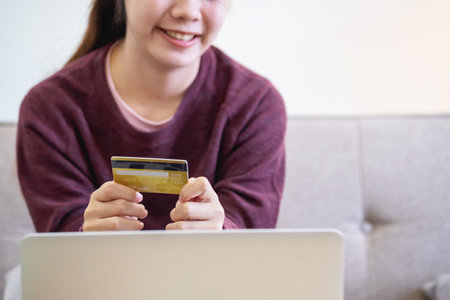 Beautiful Asian women using credit cards for shopping online with laptops and smartphones, online shopping portrait concept.の写真素材