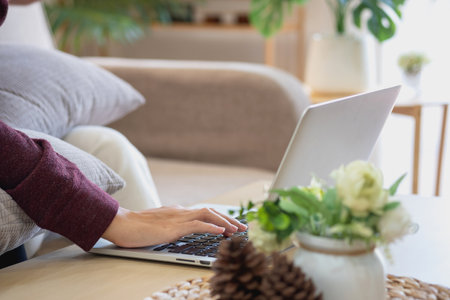 Relaxed young Asian woman enjoying relaxation on a comfy sofa at home. The beautiful girl calmly relaxes and breathes fresh air in the house. Watch movies and social networks.の写真素材