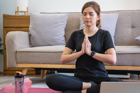 Healthy young woman doing breathing exercises at home, beautiful woman meditating at home with eyes closed, practicing yoga, doing pranayama techniques Mindfulness meditation conceptの写真素材