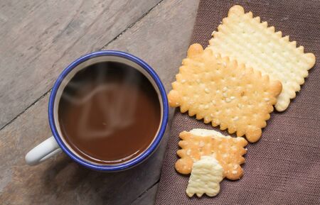 Coffee and crackers on wood surface の写真素材