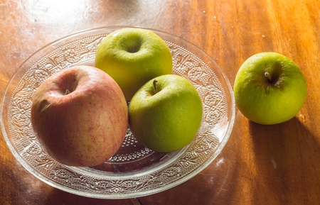 Still life green and red apple on dish の写真素材