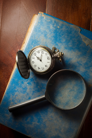 Still life Magnifier and pocket watch on antique book.の写真素材