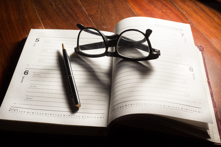 Still life Eyeglasses and pen on plan book.の写真素材