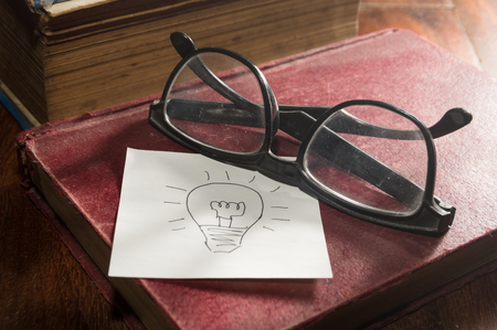 Still life Eyeglasses and book with idea note paper.の写真素材