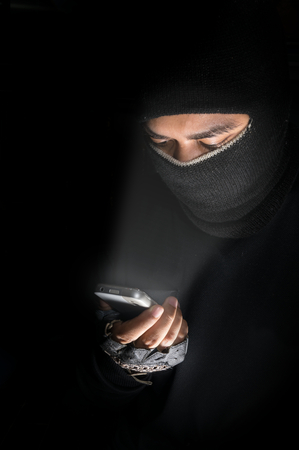 Robber man hacking by smart-phone,hacker concept.