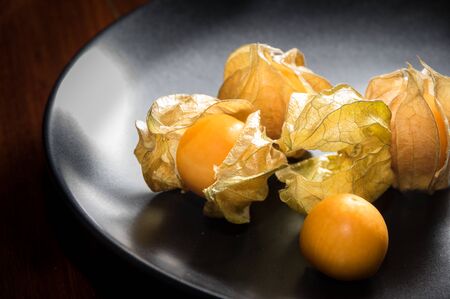 Physalis fruit or capegooseberry on black plate.の写真素材