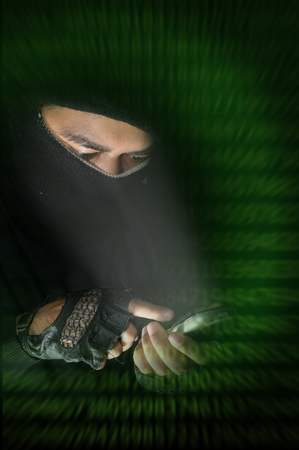 Hacker using smart phone with digital code screen.