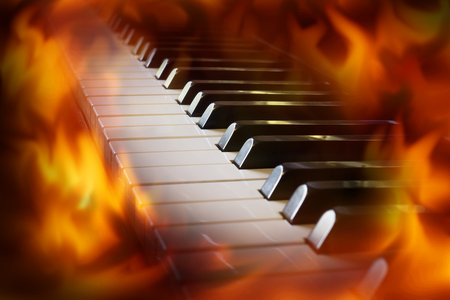 Closeup piano keyboard with fire flame screen. Music conceptの写真素材