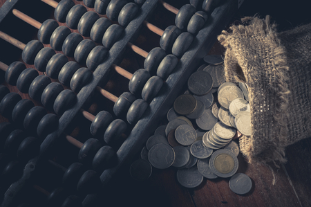 Abacus with coins in gunny sack,vintage filtered.