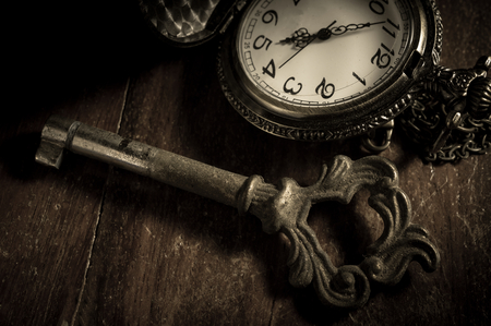 Old key with pocket watch,vintage color  filtered.の写真素材