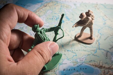 Human hand with soldier toys on map,war concept.の写真素材