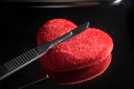 Scalpel on red heart,medical concept.の写真素材