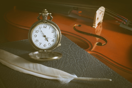 Vintage filtered,Watch with feather on book and violin.の写真素材
