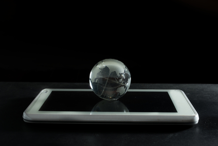 Glass globe with computer tablet.の写真素材