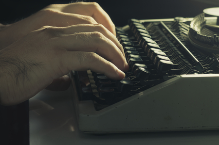Hands typing with typewriter,vintage filtered.の写真素材