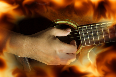 Playing guitar with fire flame screen.の写真素材