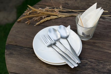 Spoon and fork on dish with napkin in glass.の写真素材