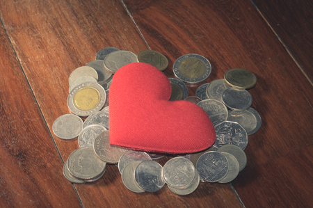 Vintage filtered, red heart on coins heap.の写真素材