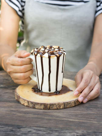 Hot coffee with marshmallow cup in woman hand.の写真素材