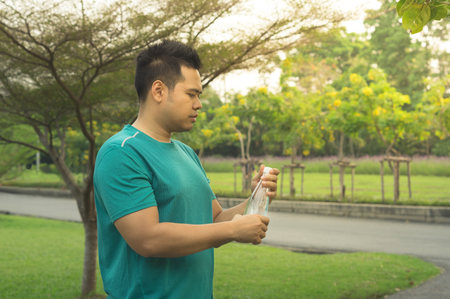 Asian man rest and drink water after exercise.の写真素材