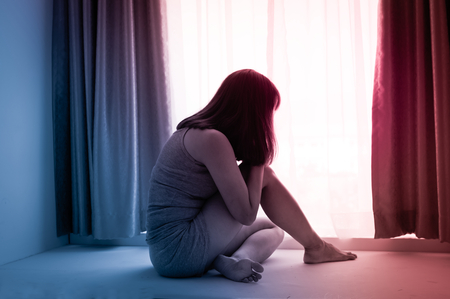 Woman crying at window side.の写真素材