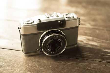 Retro old film camera on table,vintage filtered.の写真素材