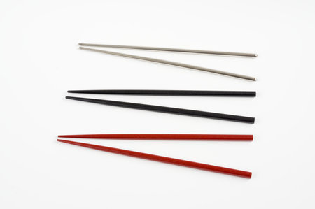 Wooden red , black and metal grey chopstick on white background.の写真素材