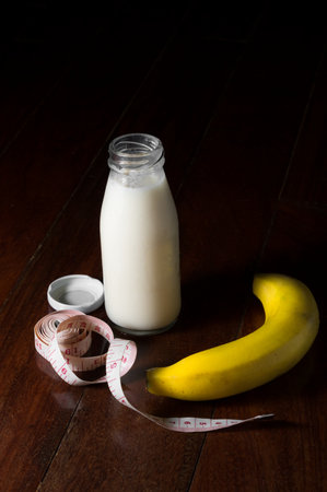 Milk bottle with banana and measuring tape.の写真素材