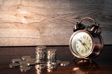 Still life alarm clock with stacked of coins.の写真素材