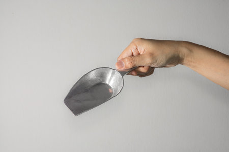 Woman hand holding big metal scoop.の写真素材