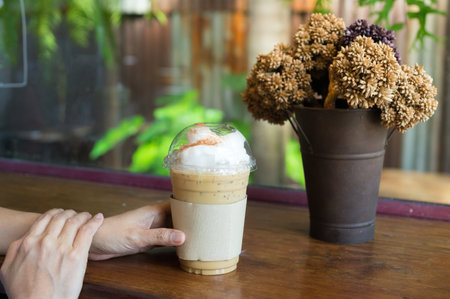 Woman drink iced coffee in plastic glass.の写真素材